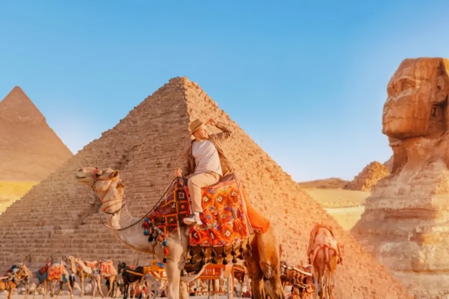 A tourist enjoys the ride camel at the Pyramids - Guided Trips to Egypt: Packages, Prices & Best Itineraries for 2026 - Egypt Tours Group