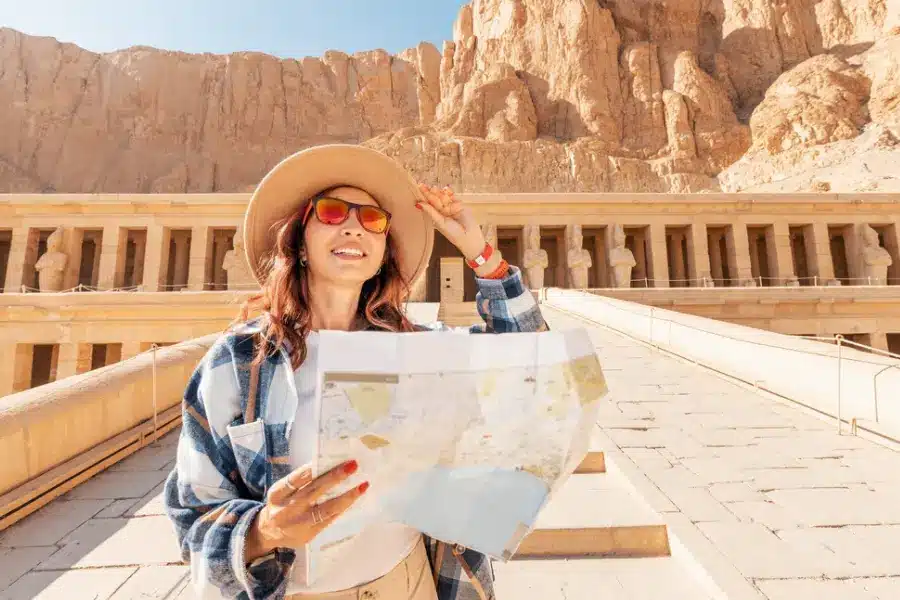 A tourist reads tombs map at Valley of the Kings- Trip to Egypt Cost from USA: Full Budget and Travel Expenses Guide - Egypt Tours Group