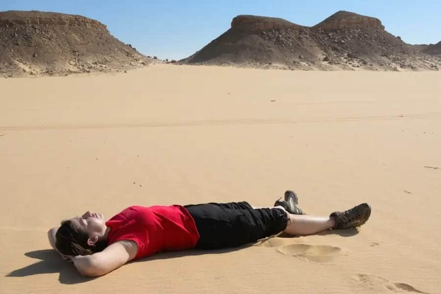 A tourist taking sunbath at the Black Desert - The Black Desert Egypt - Egypt Tours Group