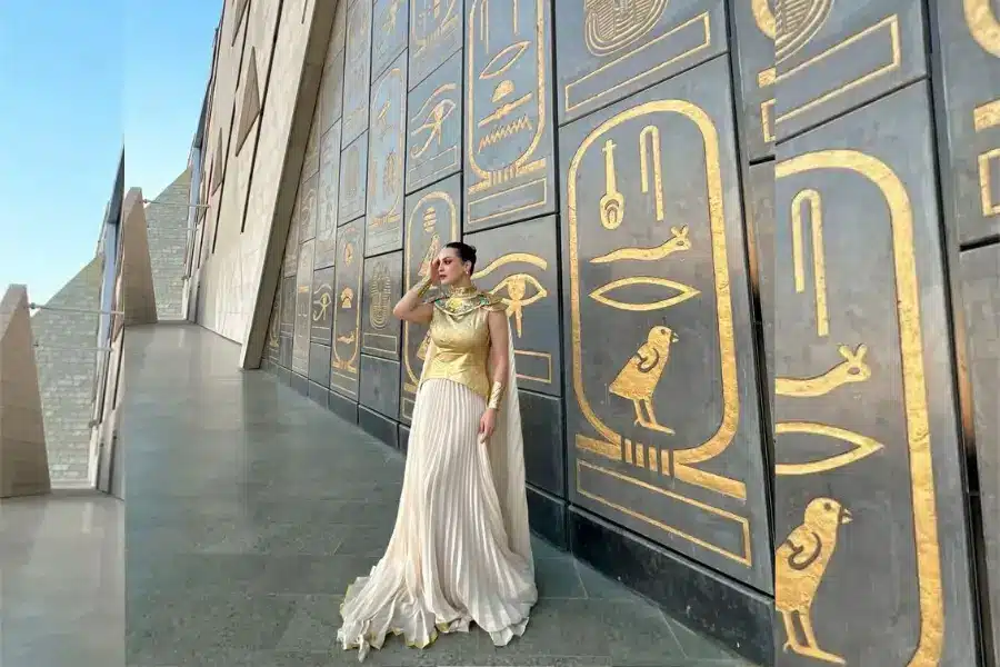 A woman takes a photo with the amazing background of GEM - Grand Egyptian Museum: Tickets, Hours & Complete Visitor Guide (2026) - Egypt Tours Group