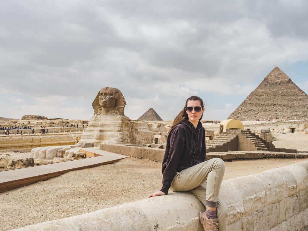 A girl siting in front of the Giza Pyramids during the 6 Days Cairo, Alexandria, Luxor & Abu Simbel Tour Package