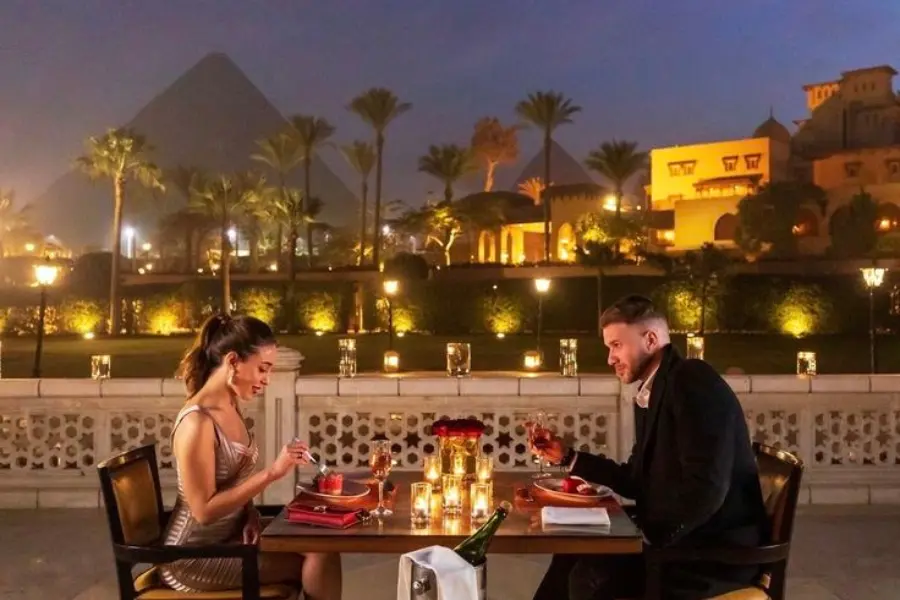 A couple having their romantic dinner by the pyramids- Egypt Honeymoon Guide: Romantic Itineraries, Best Hotels & What to Expect- Egypt Tours Group