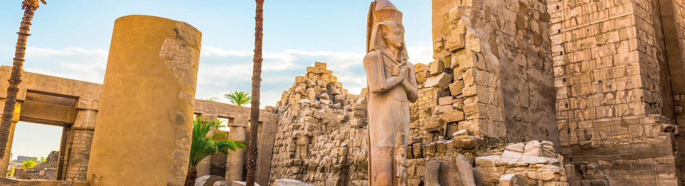 Walking through the columns and statues of Karnak Temple in Luxor during 6 Days Cairo, Luxor, Aswan, and Abu Simbel Tour
