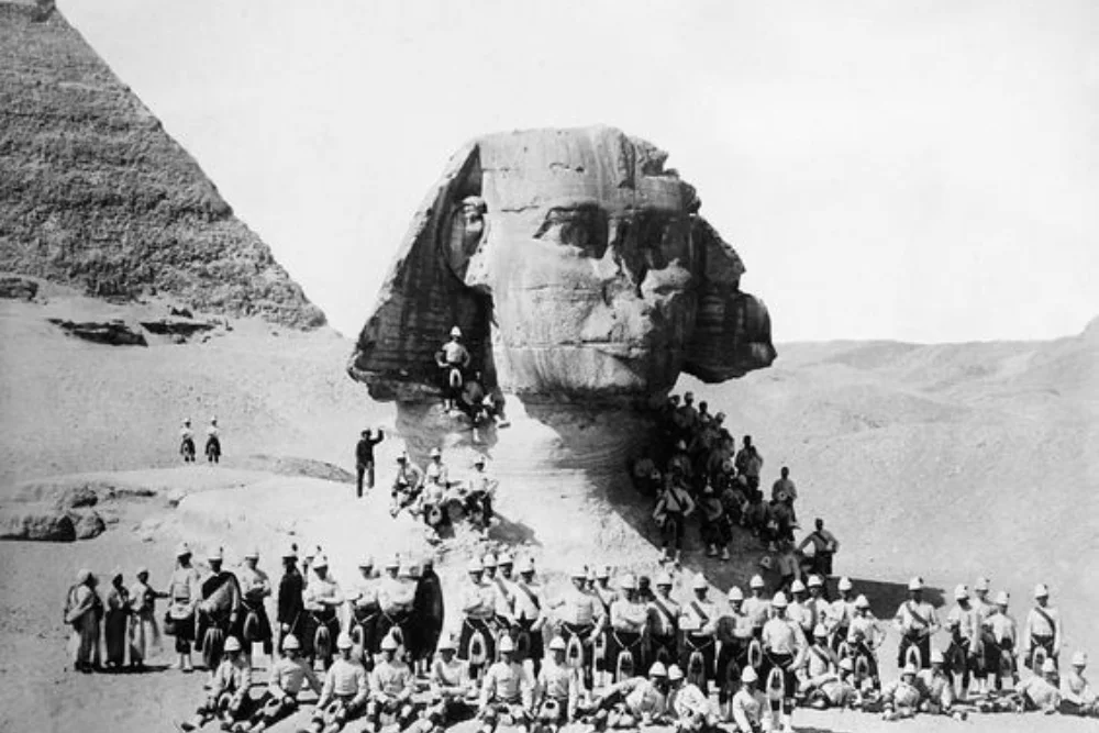 Historical photograph of people beside the partly sand-buried Great Sphinx