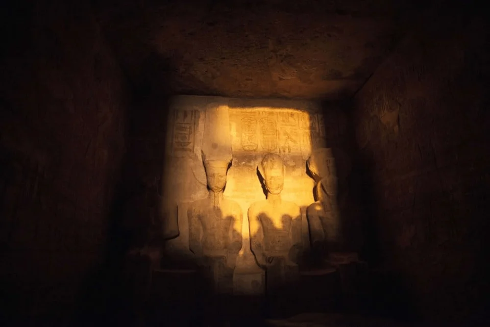 Sunlight on seated figures in the Great Temple sanctuary at Abu Simbel.