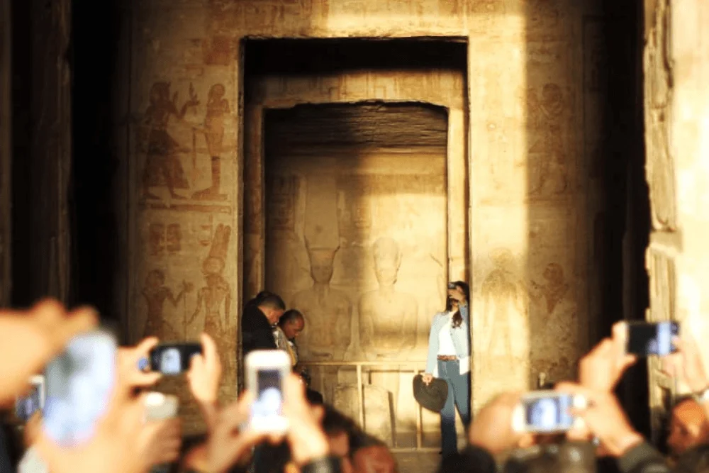 Visitors photographing the sanctuary through the Great Temple doorway at Abu Simbel.