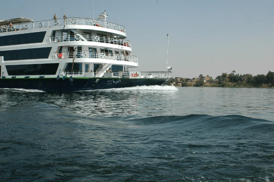 Nile cruise ship sailing past a green riverbank
