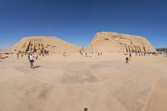 Abu Simbel Temple – Panoramic Forecourt View Tourists exploring the iconic Abu Simbel Temple in southern Egypt