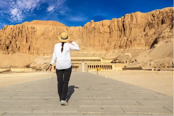 Temple of Hatshepsut – Terraced Mortuary Temple Female traveler walking towards the Temple of Hatshepsut at Deir el-Bahari
