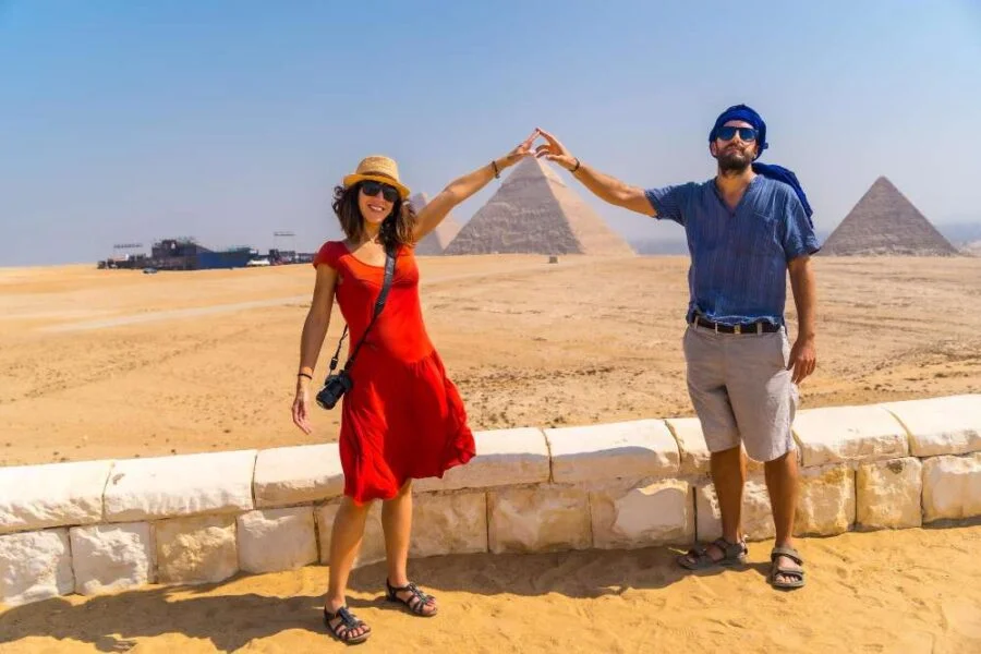 Egyptian newlyweds embrace in front of the Great Pyramids.