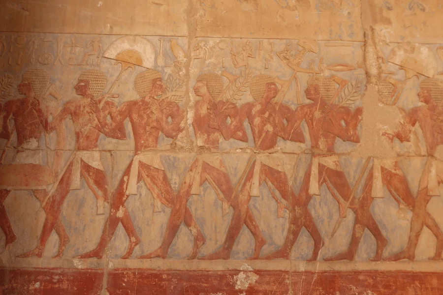 Row of Egyptian-style figures in a painted relief.