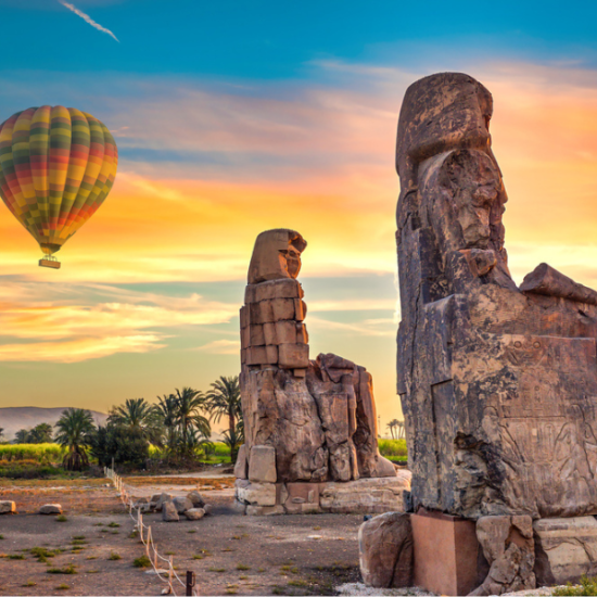 The massive twin statues of the Colossi of Memnon standing tall in Luxor, Egypt.