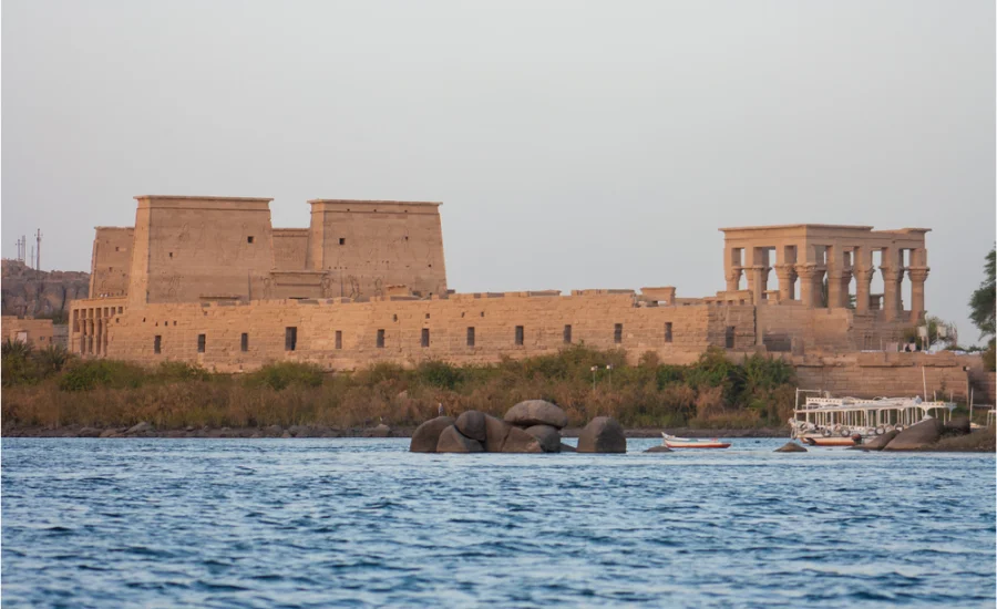 The Philae Temple in Aswan, Egypt, dedicated to the goddess Isis, surrounded by clear waters.