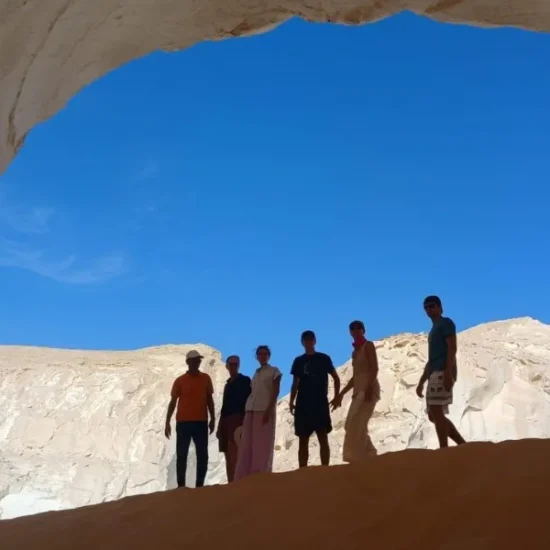 Travelers exploring a natural rock cave in the White Desert during a 5 Days Cairo and Bahariya Oasis Tour