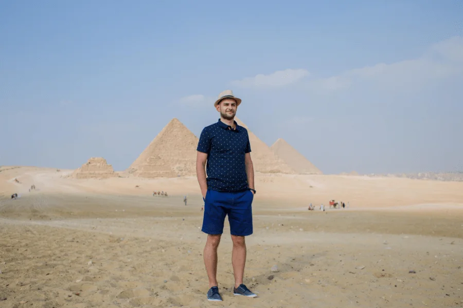 A visitor standing in front of the pyramids of Giza.