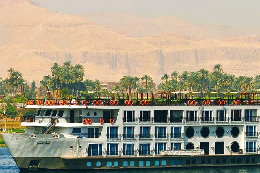 Cruise ship on the Nile River with Cairo skyline - 6 Days Cairo, Luxor, Aswan & Abu Simbel Easter Tour