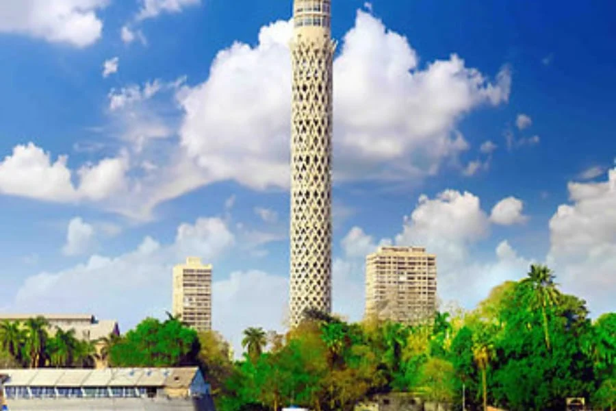 Cairo Tower rising above trees under a blue sky