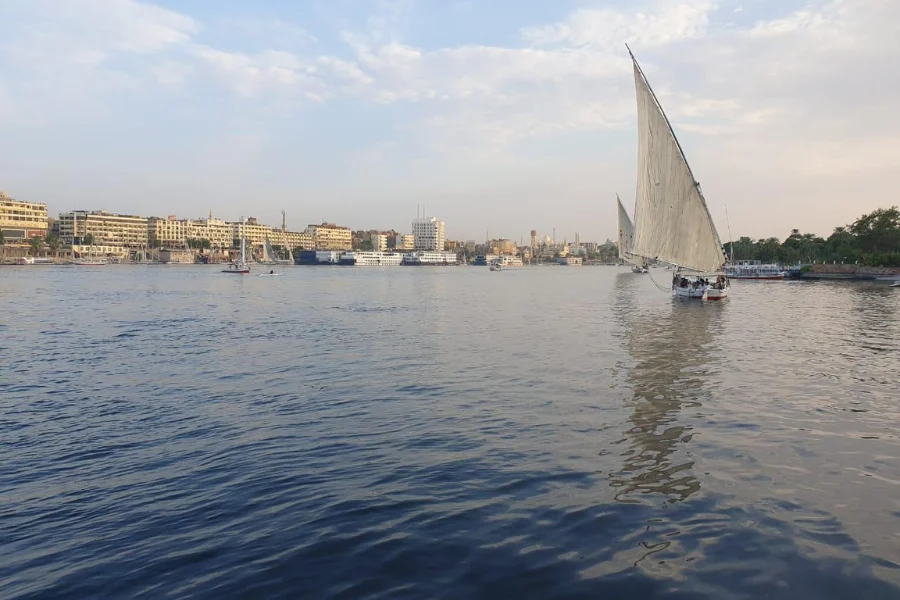 A traditional felucca sailing on the Nile River in Aswan, Egypt.