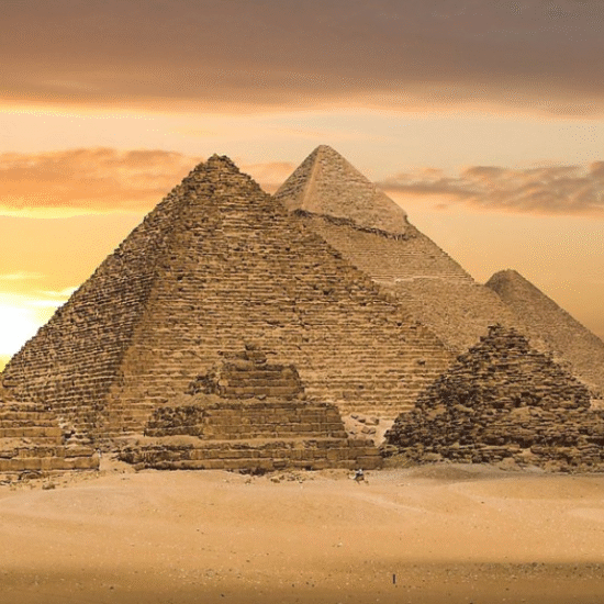 Morning view of the Great Pyramids of Giza with golden sunlight over the desert
