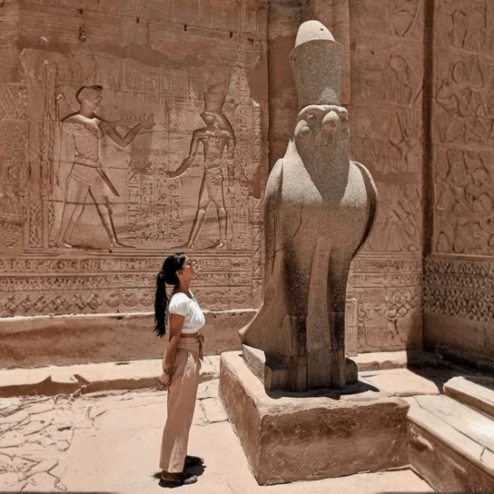 A girl standing in front of Edfu Temple entrance