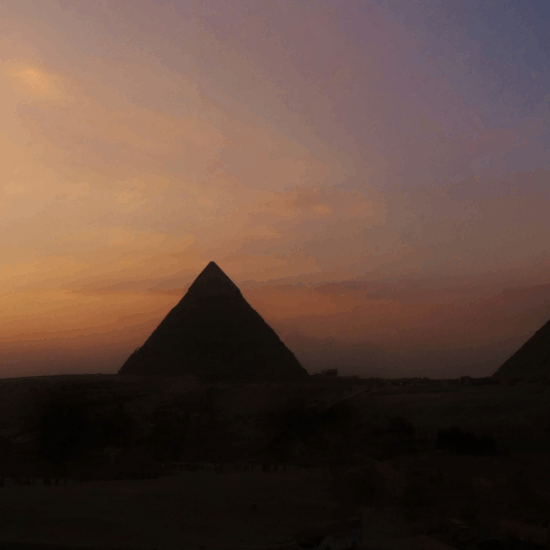 The Great Pyramids of Giza at sunset, glowing under the golden sky of Egypt.