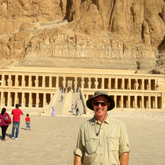 An elderly man standing in front of Hatshepsut Temple, Egypt