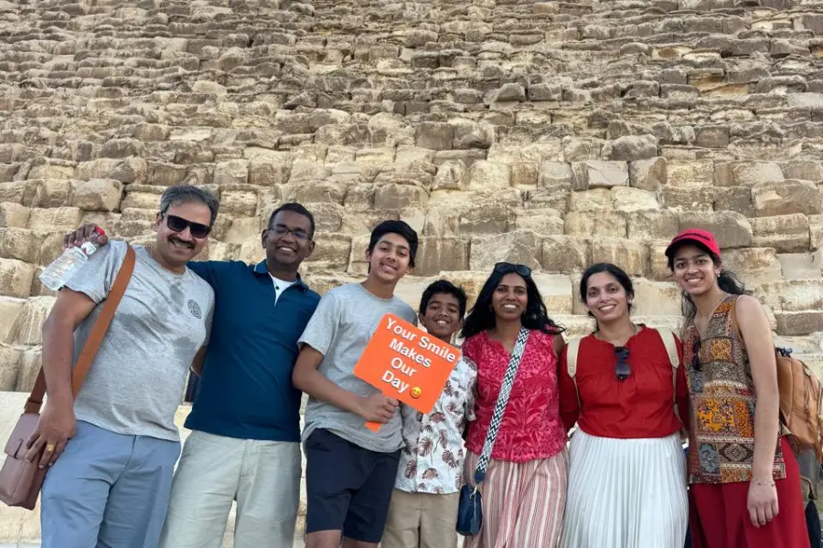 A family standing in front of the Pyramids of Giza in Egypt