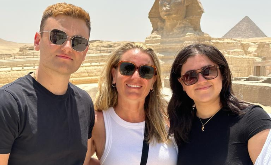 A family standing in front of the Pyramids of Giza