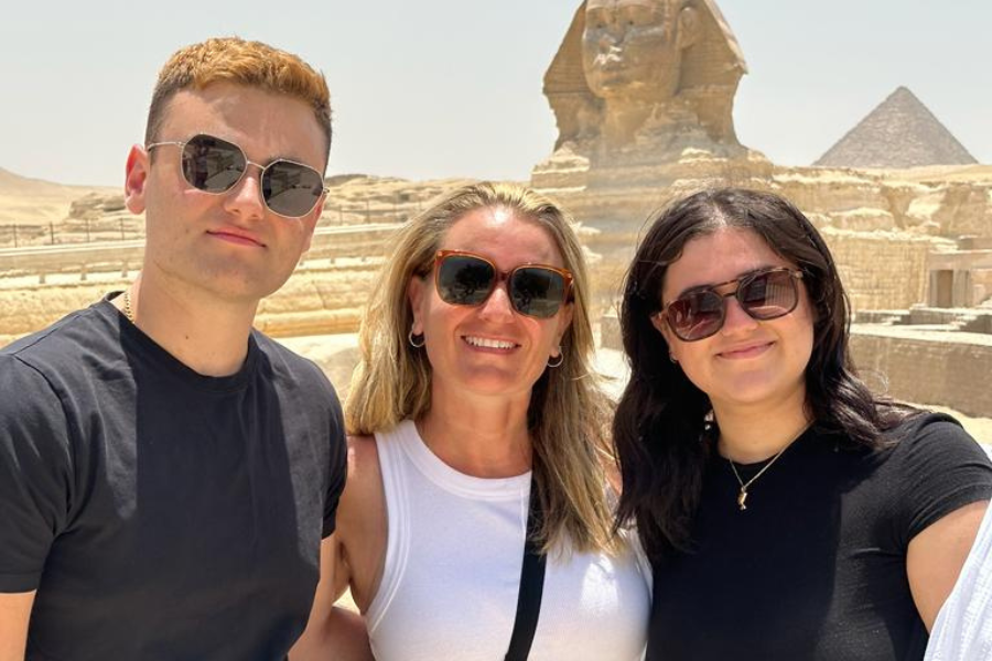 A family standing in front of the Pyramids of Giza