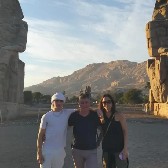 A family standing in front of the Colossi of Memnon