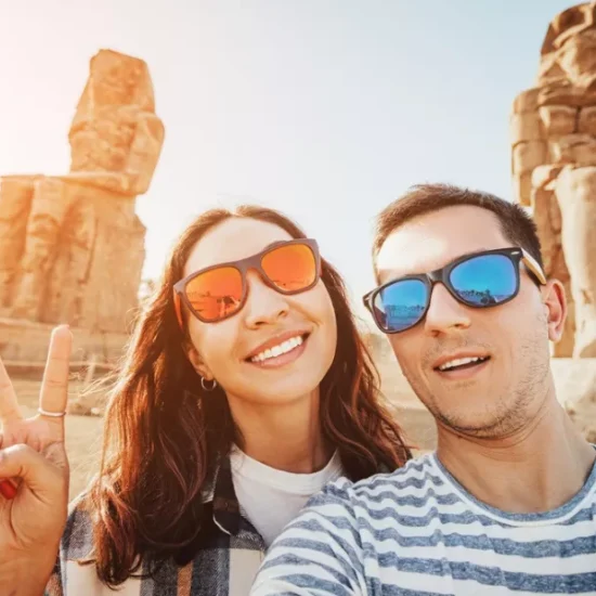 Couple taking a selfie in front of the Colossi of Memnon during our 10 Days Cairo, Nile Cruise & Alexandria Family Tour