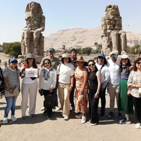 Tour guests standing in front of the Colossi of Memnon