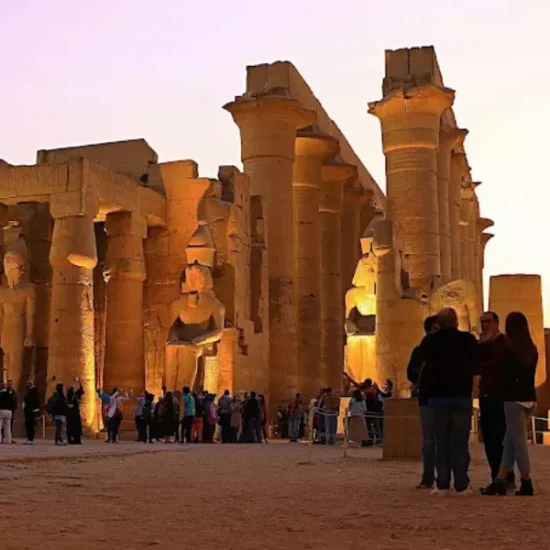 Luxor Temple illuminated at night with visitors