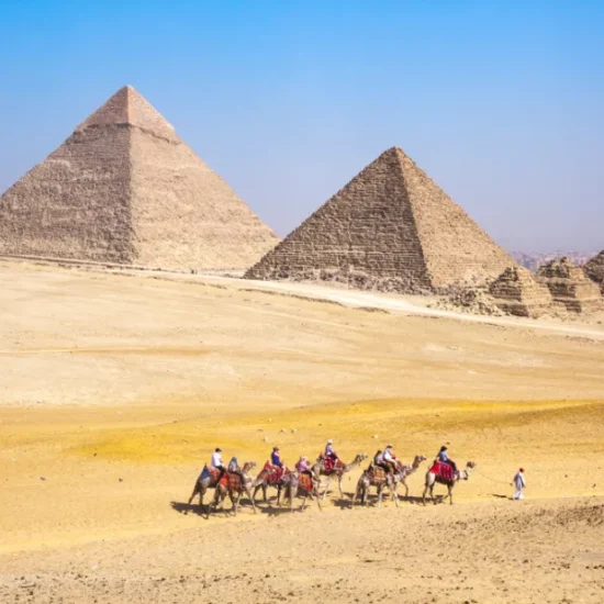 Tourists visiting the Pyramids of Giza in the morning