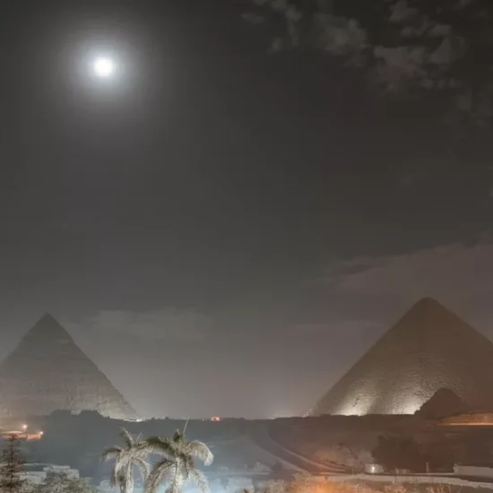 Pyramids of Giza at night with moon