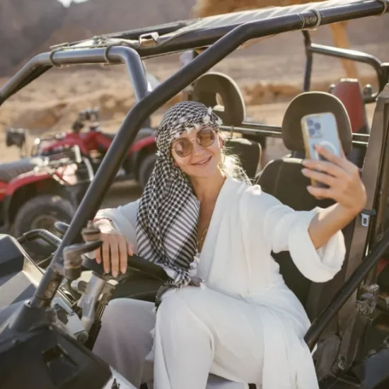 Tourist taking selfie on beach buggy safari