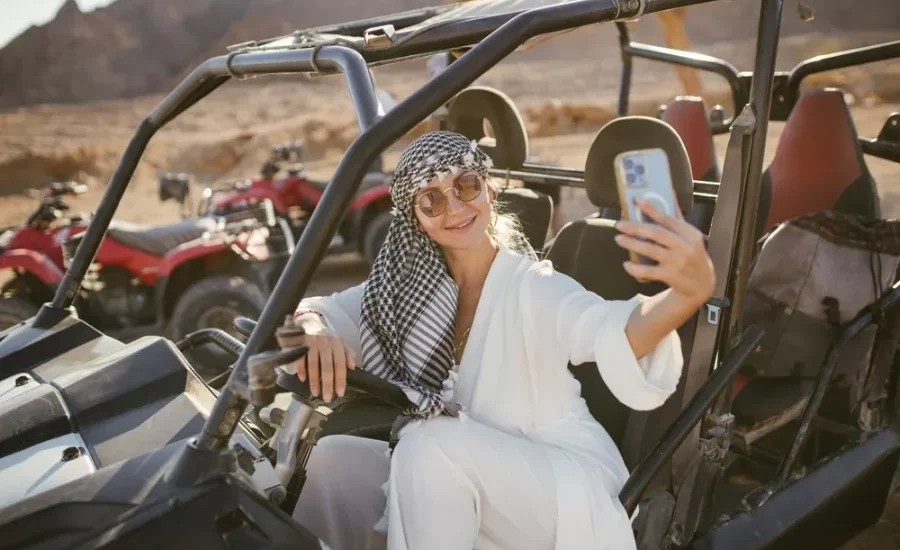 Tourist taking selfie on beach buggy safari