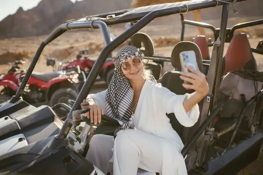 Tourist taking selfie on beach buggy safari