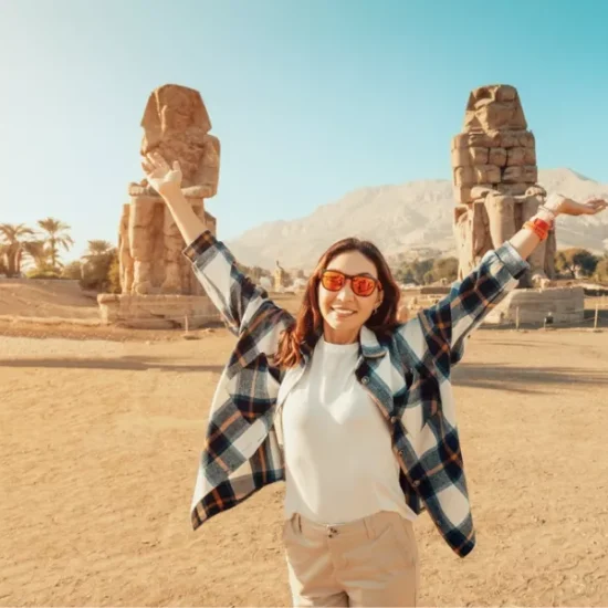 Tourist standing in front of the Colossi of Memnon