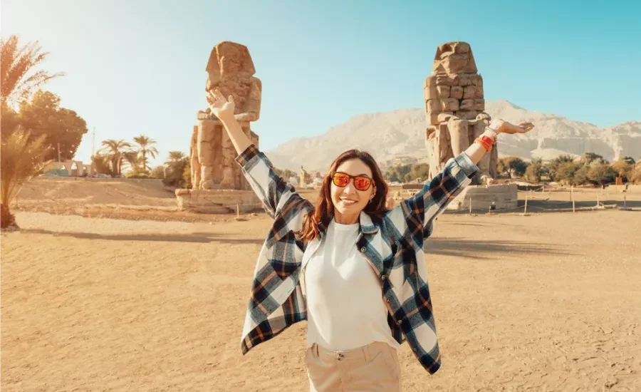 Tourist standing in front of the Colossi of Memnon