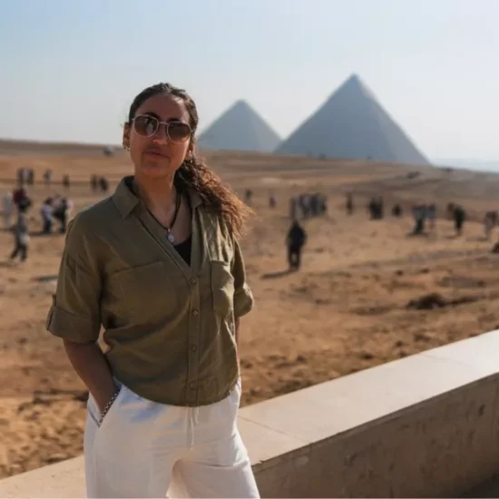 Tourist standing in front of the Pyramids of Giza during the 5 Days Cairo and Luxor Budget Tour