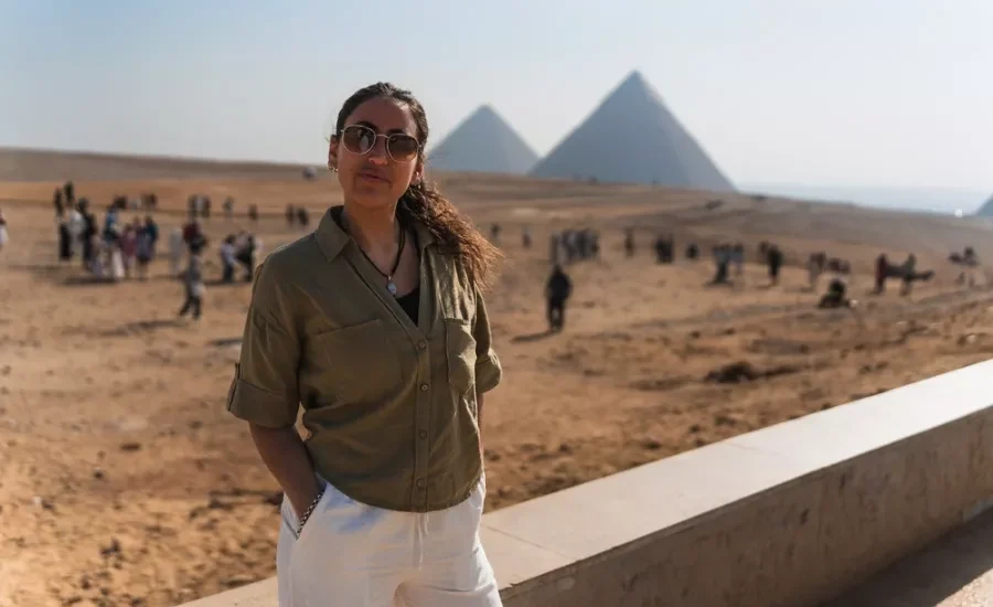 Tourist standing in front of the Pyramids of Giza during the 5 Days Cairo and Luxor Budget Tour