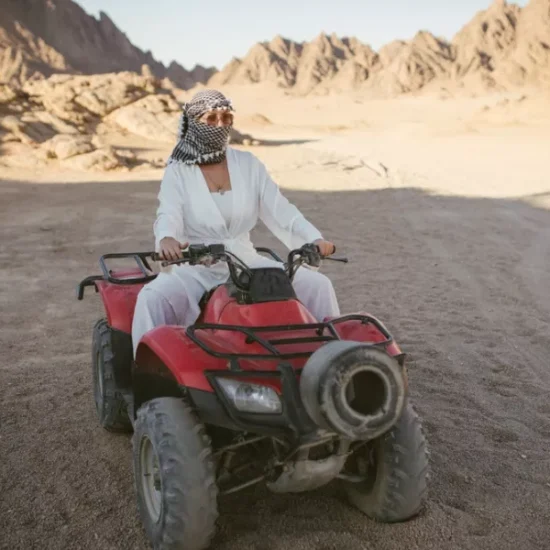 Female tourist riding beach buggy desert