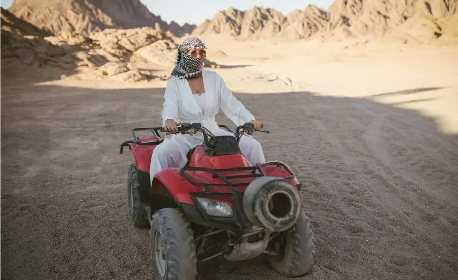 Female tourist riding beach buggy desert