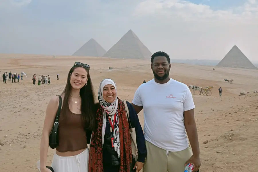 Tourists at the Giza Pyramids greeting their Egyptian guide using Ezayak