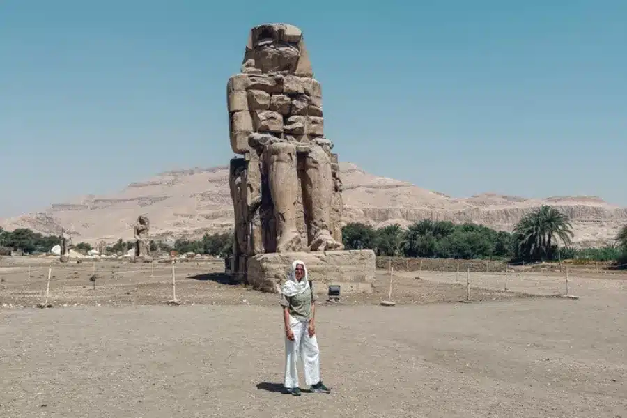 Tourist standing before Colossi of Memnon