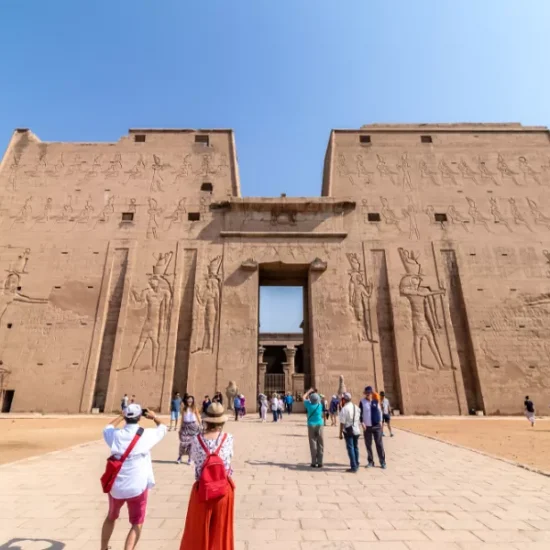 Couple standing in front of Edfu Temple in Aswan, part of our 6 Days Cairo, Luxor & Aswan Affordable Tour
