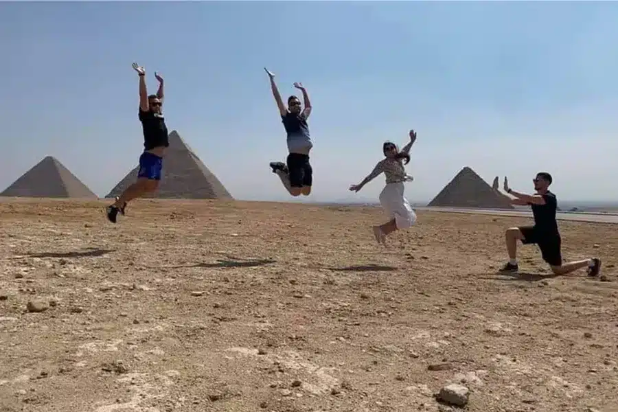 Tourists laughing and jumping near the Giza Pyramids in Egypt - Egyptian Slang Words