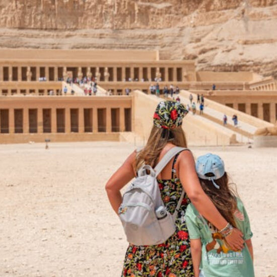 Mother and daughter standing at Hatshepsut Temple from behind