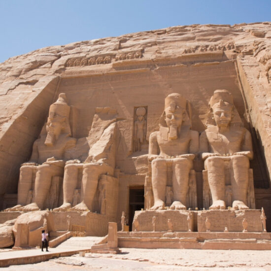 Tourist standing at the entrance of Abu Simbel Temple a part of our 6 Day Cairo, Alexandria, Luxor & Abu Simbel Cheap Tour